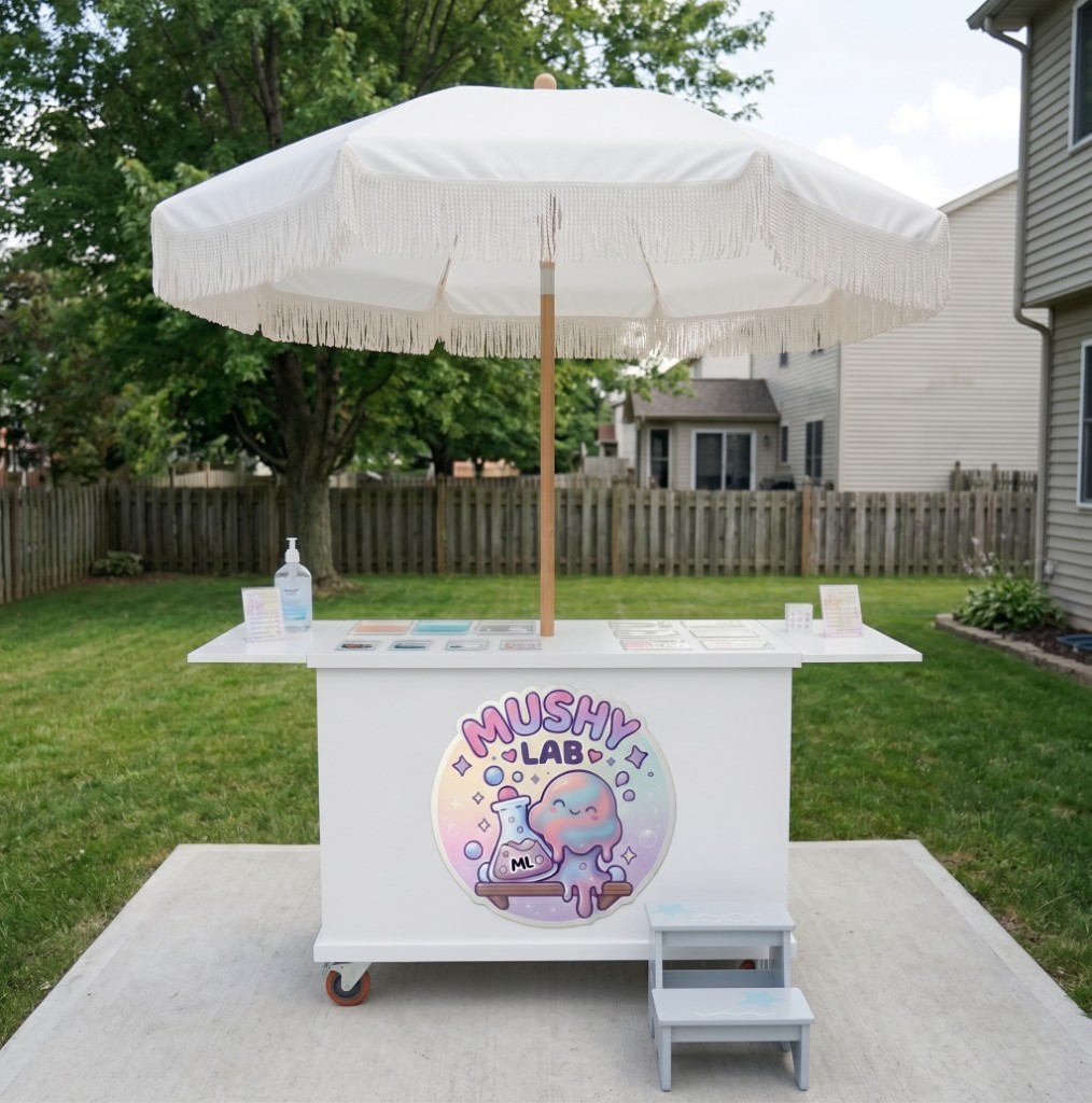 White Mushy Lab cart with a fringed umbrella set up on a backyard patio