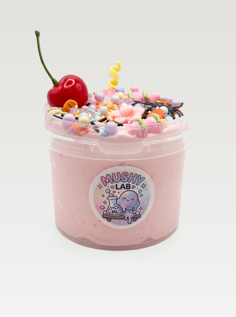Pink Mushy Lab slime in a clear tub, topped with a cherry, sprinkles, and candy