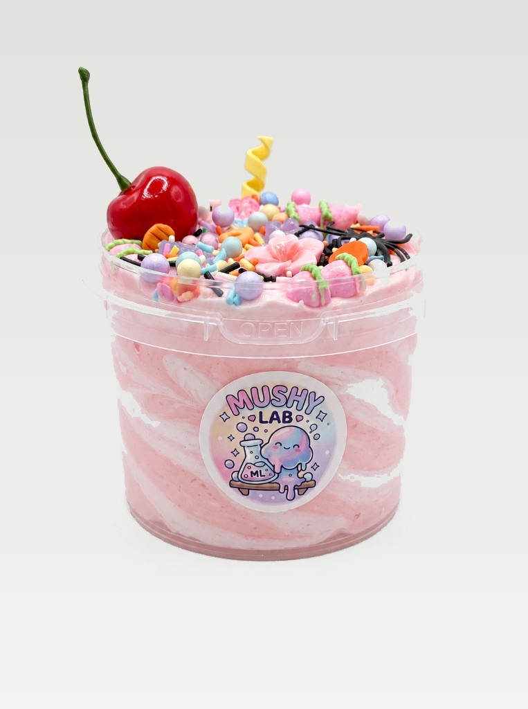 Pink and white swirled Mushy Lab slime in a clear tub, topped with a cherry, sprinkles, and candy